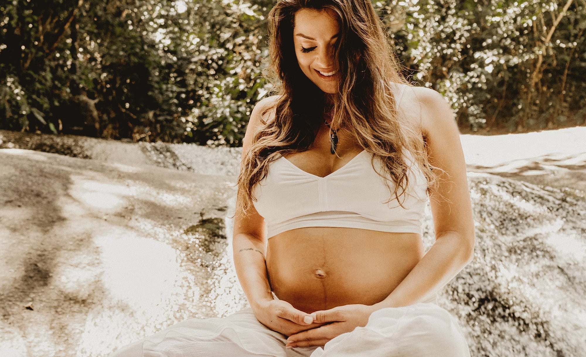 Femme enceinte et heureuse de regarder son ventre rond