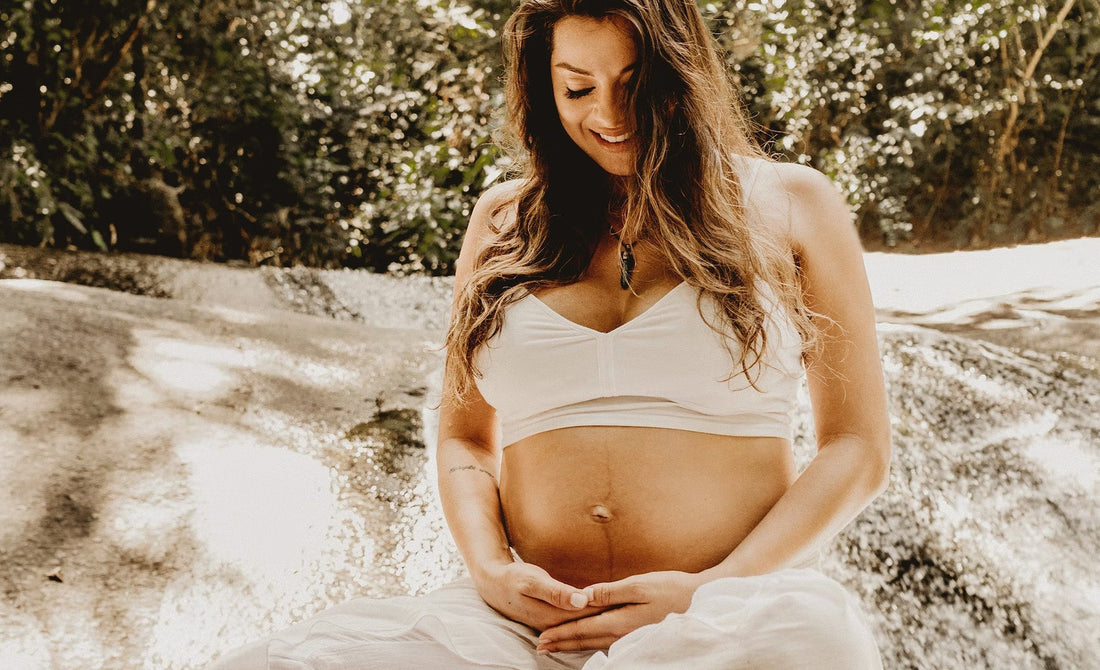 Femme enceinte et heureuse de regarder son ventre rond